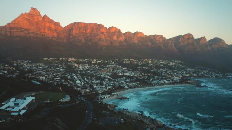 A serene desert landscape with golden sand dunes under a clear blue sky, showcasing the natural beauty of a remote desert environment, cape town.