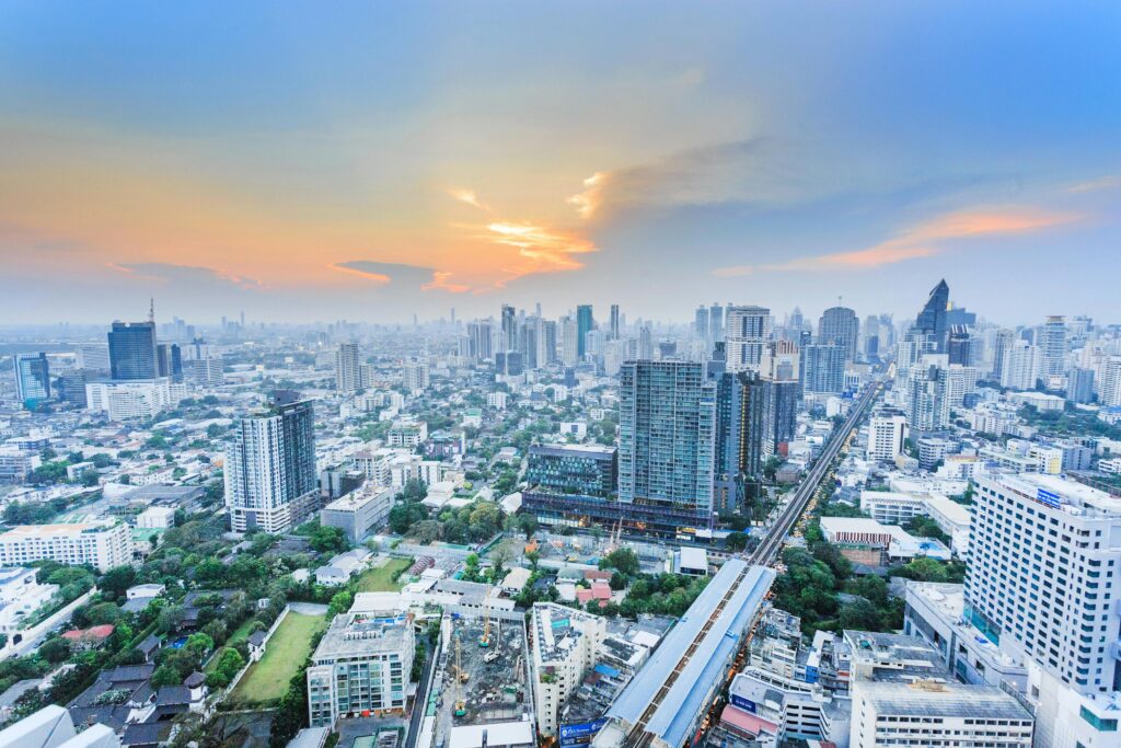 Stunning aerial view of the bustling Bangkok skyline at sunset, showcasing the city's towering skyscrapers and modern architecture.