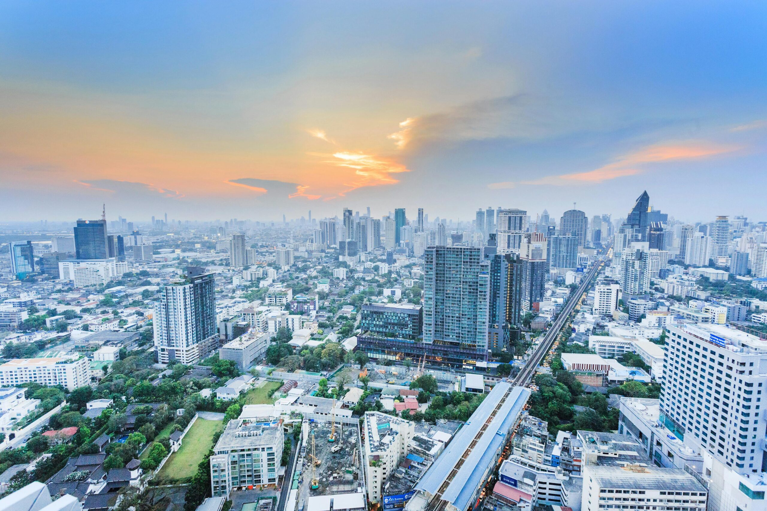 Stunning aerial view of the bustling Bangkok skyline at sunset, showcasing the city's towering skyscrapers and modern architecture.