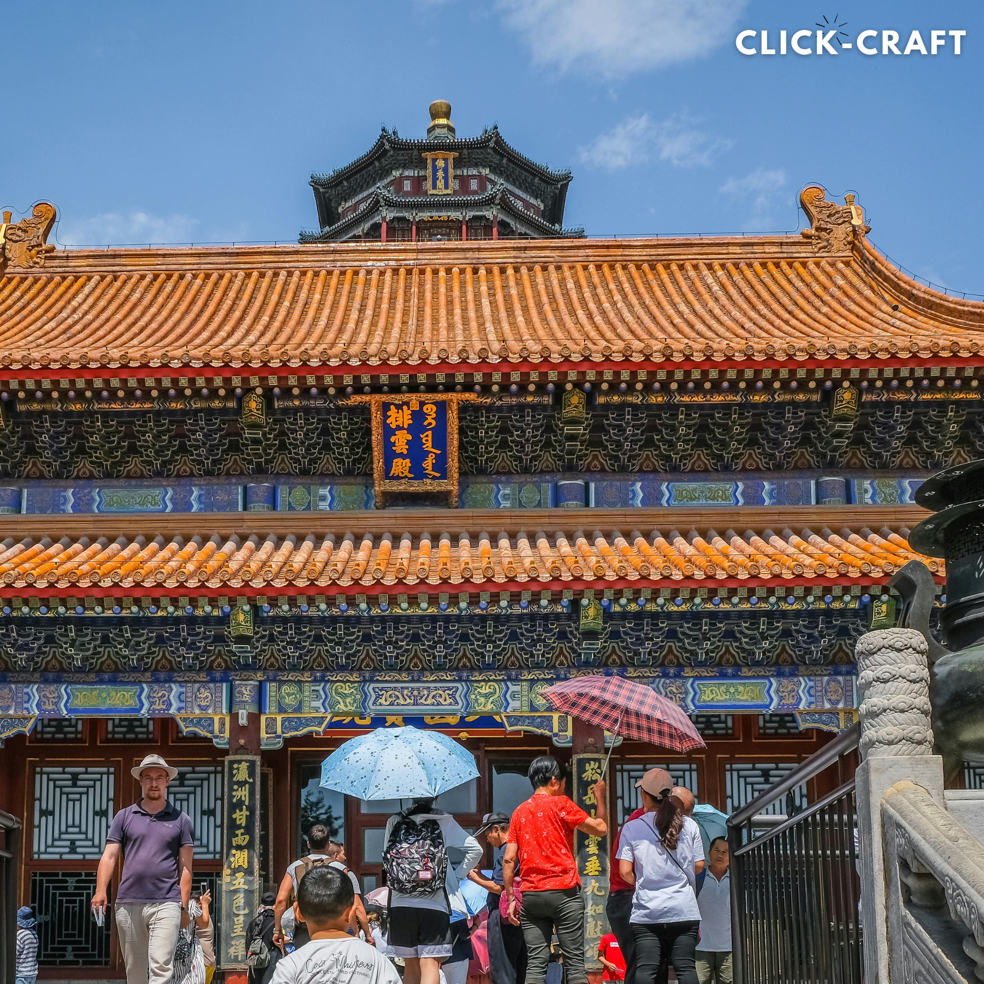Colorful and ornate traditional Chinese architecture with visitors walking under umbrellas. Beijing